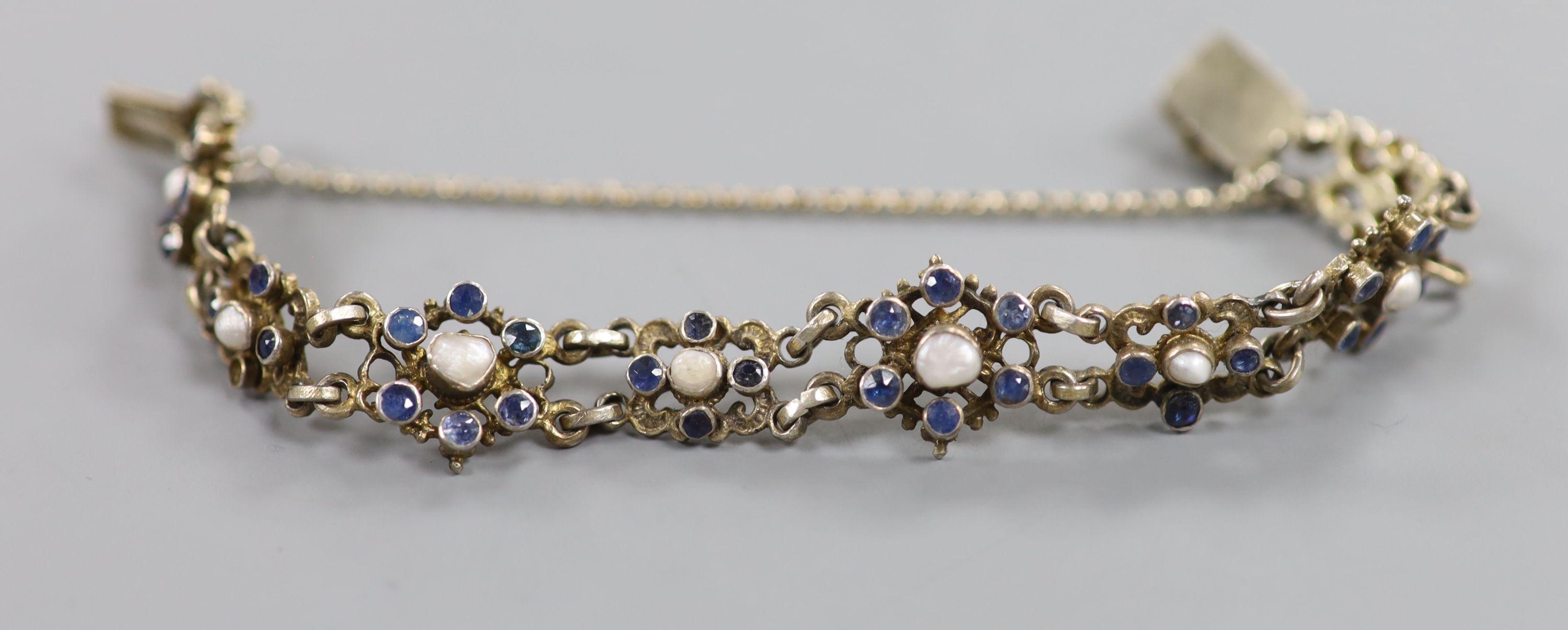 A continental gilt white metal, sapphire and split pearl flower head cluster set bracelet